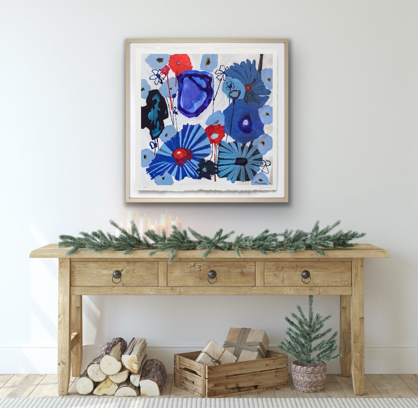 Wooden console table with decorative items against a white wall with abstract floral artwork.