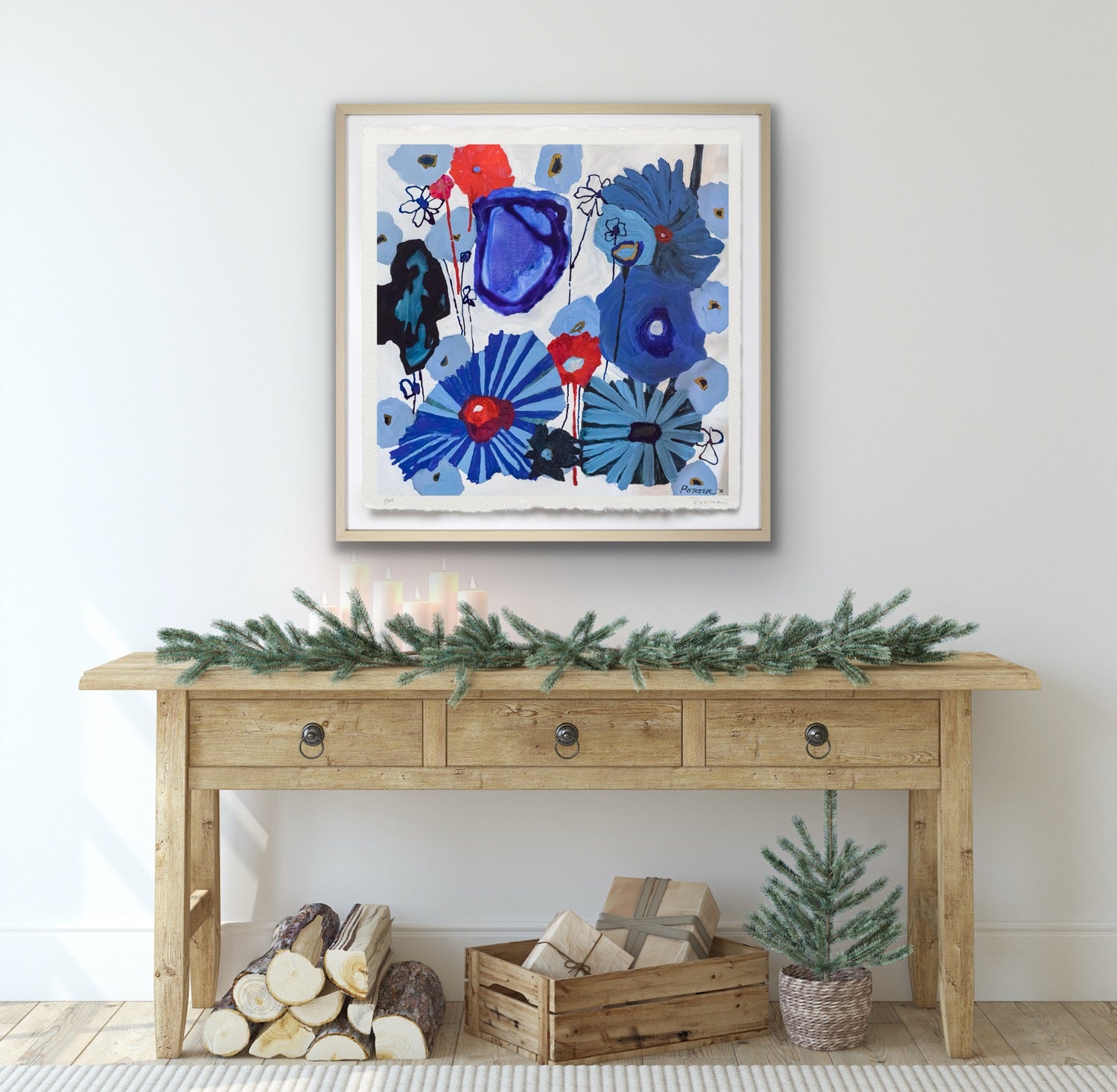 Wooden console table with decorative items against a white wall with abstract floral artwork.