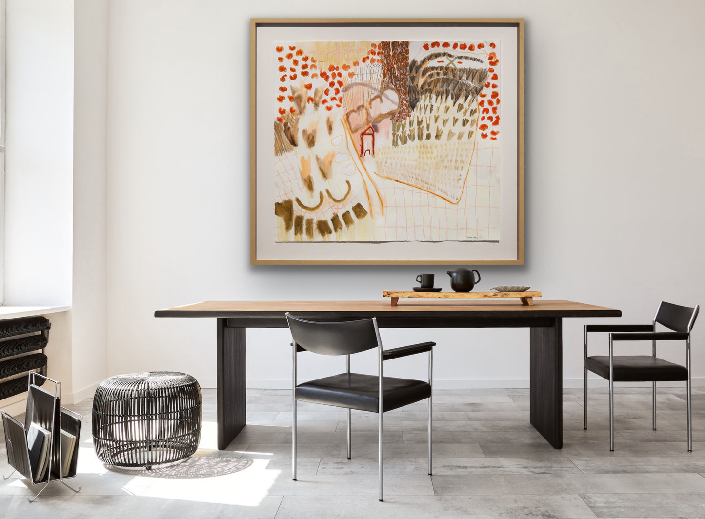Dining room and office with a wooden table, black chairs, and a framed abstract painting on the wall.