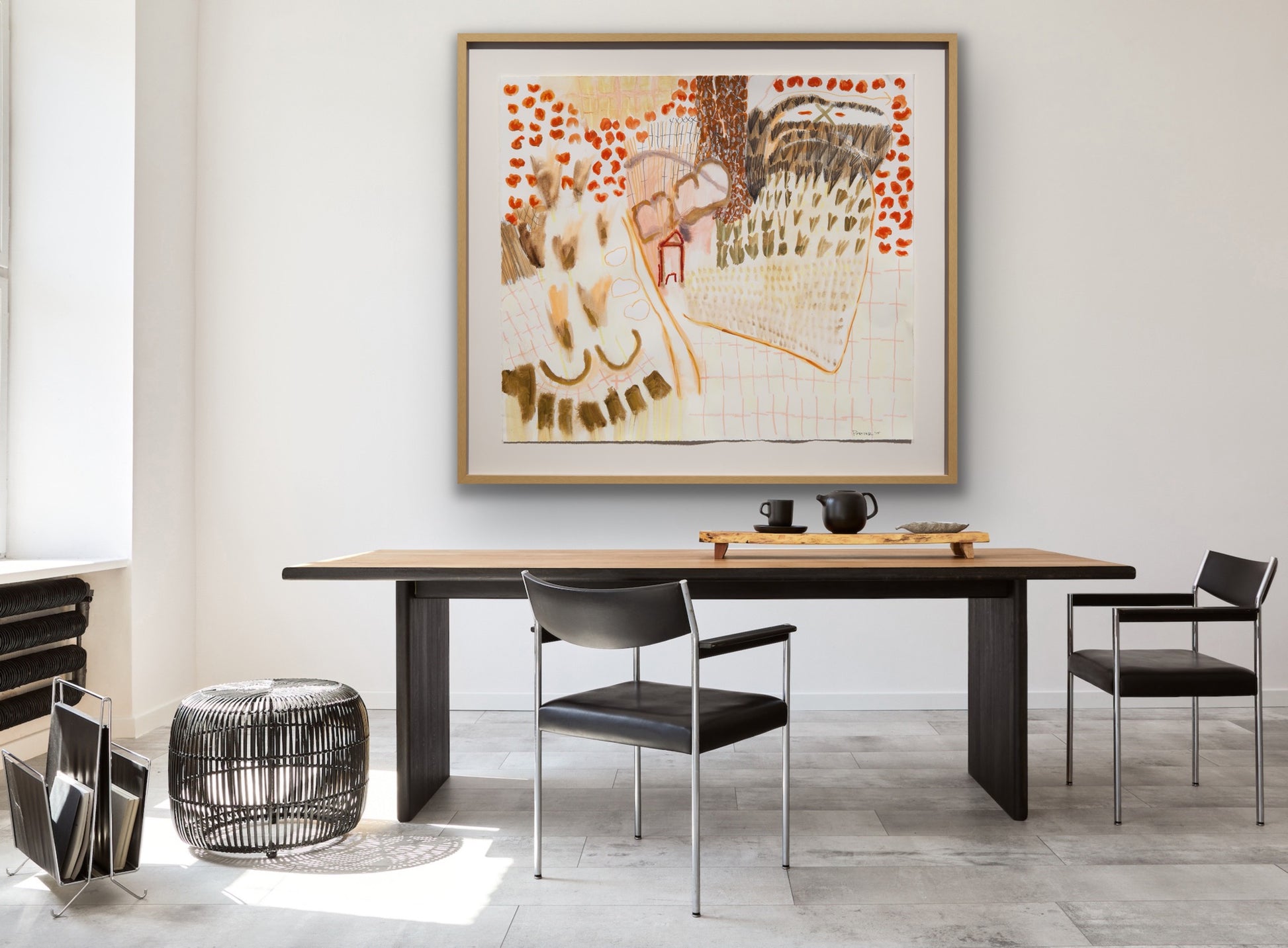 Dining room and office with a wooden table, black chairs, and a framed abstract painting on the wall.