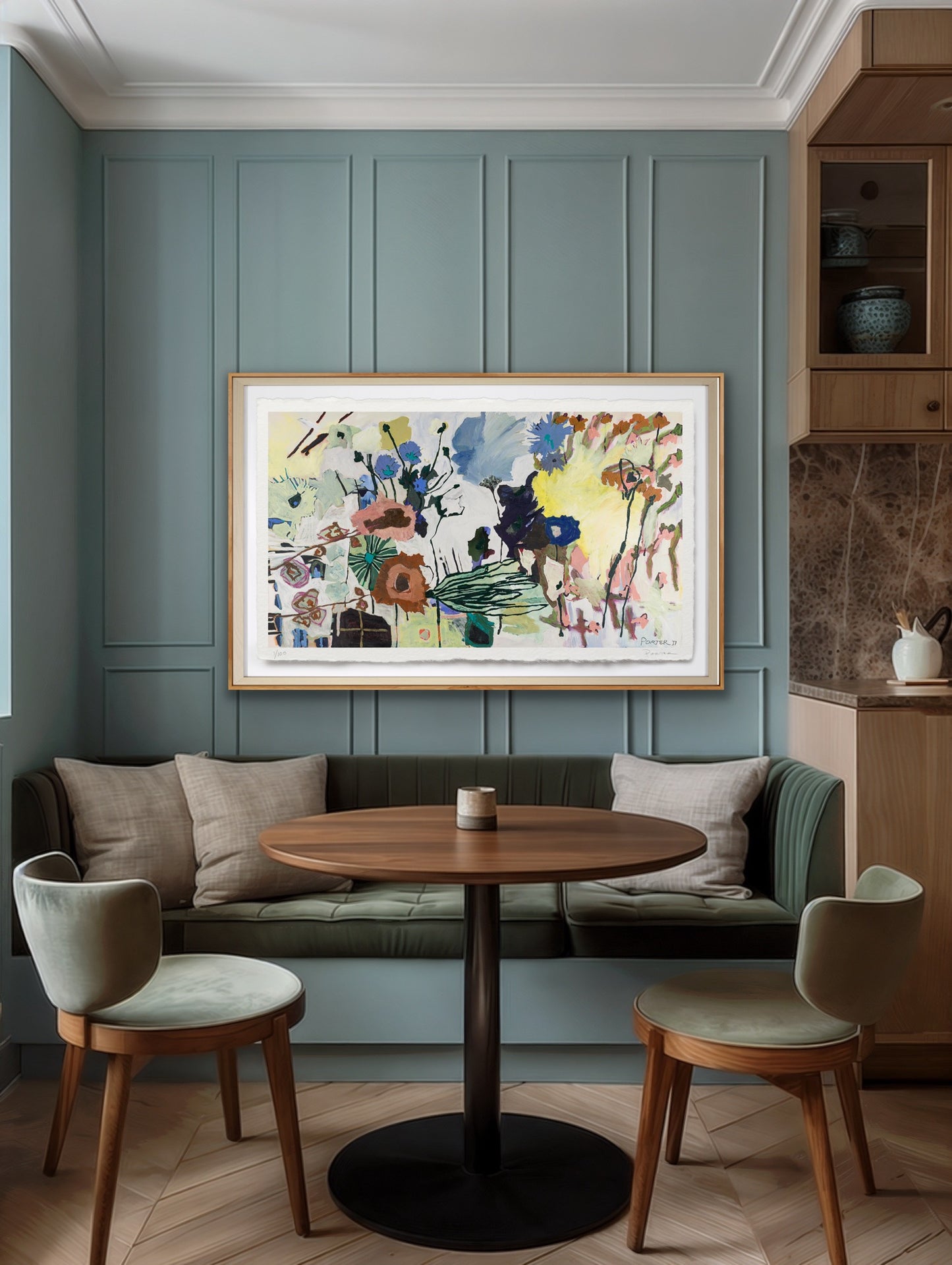 Modern living room with a round wooden table, chairs, and a colorful abstract painting on a green paneled wall.